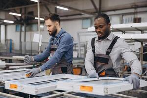 Factory workers assembling PVC window frames in production line photo