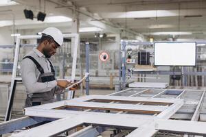 Engineer inspecting PVC window frame in factory photo