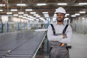 Supervisor posing with arms crossed in window factory photo