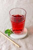 Red berries and fruits drink in the glass on the light background. photo