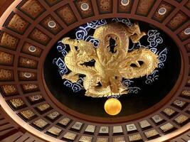An ornate dragon-shaped ceiling adorns the banquet hall. photo