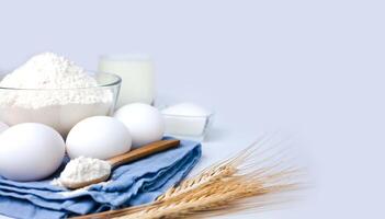 Baking ingredients. Flour, eggs, milk and sugar on the white background. Cooking process. Close-up. Copy space. photo