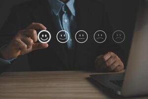 a businessman choose the virtual screen on the happy smile face icon to give satisfaction in service.rating very impressed.customer review service and Satisfaction concept photo