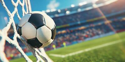 A soccer ball caught in the goal net . Background shows a blurred stadium crowd photo