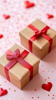 Two brown boxes with red ribbons on them, one of which has a red bow. The boxes are placed on a pink background with a lot of red hearts scattered around. Concept of love and celebration photo