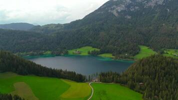 Hintersteiner See mountain lake in Austria near town of Kufstein, aerial view in summer at sunset in cloudy weather. Hintersteiner See in Oesterreich in der Nahe der Stadt Kufstein Luftaufnahme. video