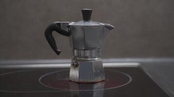 Silver mocha coffee pot on the kitchen stove. Geyser coffee maker. Making a cofee drink at home. Italian espresso maker. Geyser kettle for coffee on an induction stove. Coffee preparing in moka pot. video