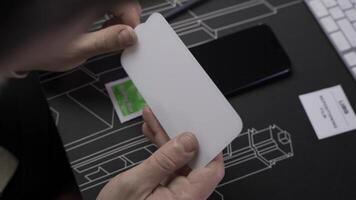 Close-up of male hand preparing and installing screen protector on smartphone. Top view of attaching protective sheet to smart phone display. Tempered glass shield protector. Maintenance and repairing video