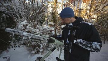 Cleaning dirt and snow off the bicycle using a brush outside the house before taking it home. Man brushes wheels of bicycle with scrub brush out front house in winter. Snow and cycling. video