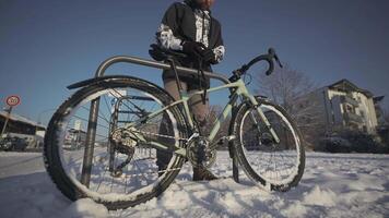 Security and antitheft lock for a bicycle. Man cyclist unlocks cycle in an outdoor bike parking lot in a European city in Germany. Guy unlocking bicycle in open rack in winter in snowy weather. video