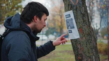 Search for missing pets. Lost dog man found her and calls the owner on an advertisement on a tree in the park. The guy dials the number from the poster about the loss of dog. Lost husky please find video