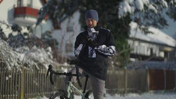 Cyclist uses smartphone to find road, building route on map, navigation in winter in snowy, sunny weather in Germany. People, sports, active lifestyle and modern technology. GPS navigation on phone. video
