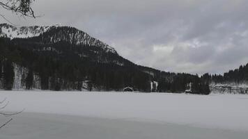 Lake Spitzingsee in winter covered with snow and ice in freezing cloudy weather in Bavaria, Germany. A mountain lake in Bavarian Alps frozen around mountain in Spitzingsee, Schlierseer Berge video
