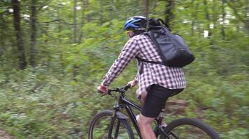 Man ride bicycle through forest, collecting trash. Trendy sports programs plogging that help preserve environment. Pollution. Ecological problem. Plastic ban awareness, national cleaning day concept. video