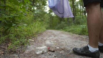 Environmental total pollution by human life products, ecological problem, global warming. Polluted forest. Bad man litters on a forest path, pours trash from a plastic bag on the ground and leaves. video