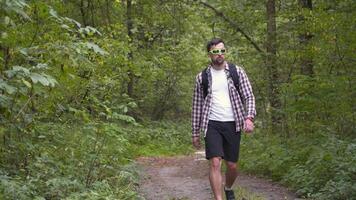 Safe planet, man hiker with backpack collects garbage in plastic trash bag in forest for clean planet, environment and ecology while walking in nature. Green volunteering. Man hand picking up garbage. video