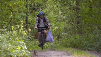 Volunteer bicyclist remove trash bags for garbage, clean up forest during bicycle ride. Save environment. Recycle waste litter rubbish garbage trash junk clean training. Picking up trash while cycling video