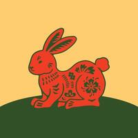 A red rabbit sitting on a green field vector