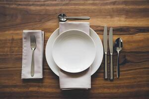 Minimalist dining table with white plate and silverware, elegant, clean arrangement photo