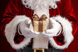 santas manos presentación un dorado regalo caja, festivo cerca arriba foto