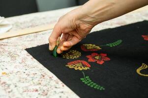 Hand block printing on fabric with bright floral patterns photo
