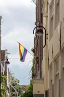 Progress Pride flag displayed on the exterior of a historic building photo