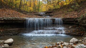 Waterfall cascading over rocks in autumn forest creating a tranquil pond photo