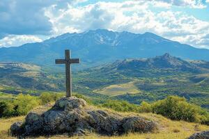 Wooden cross standing on a rock overlooking majestic mountains photo