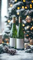 Two wine bottles with blank labels resting in snow with christmas tree lights in background photo