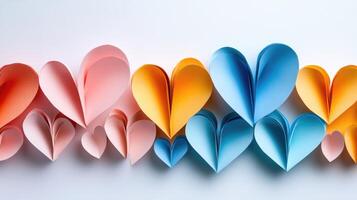Colorful paper hearts creating a gradient effect on white background photo