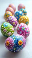 Twelve colorful hand-painted easter eggs forming a square on white background photo