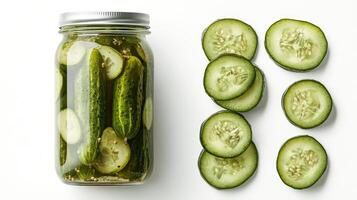 Pickled gherkins and sliced cucumber displayed on white background photo