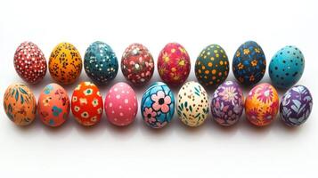 Twelve colorful hand-painted easter eggs forming a square on white background photo