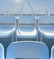 Rows of white chairs in an empty auditorium photo