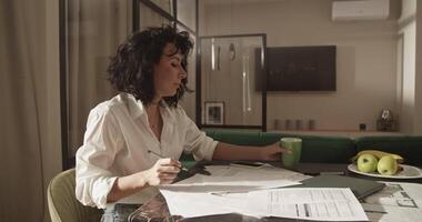 Female architect drinking coffee and working on project video