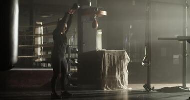 Powerful young sportswoman practicing kettlebell swing exercise in club video