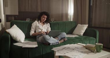 Female architect using laptop on sofa video