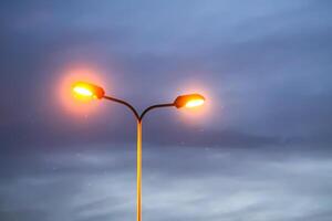 A row of street lights against the night sky. photo