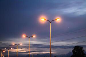 A row of street lights against the night sky. photo