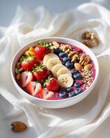 A bowl of fruit and nuts is topped with a bowl of berries and nuts photo