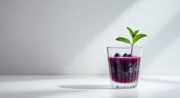 A glass of blueberry juice with a plant growing in it photo
