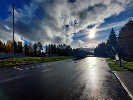 Sun reflections on wet asphalt of resting place in Sweden photo