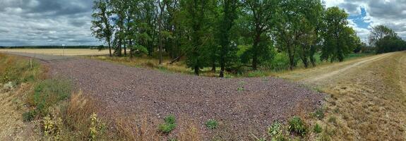 Panorama of small road ending in gravel and dirt road photo