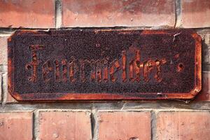 Historic rusty sign with the German word Feuermelder - fire alarm photo