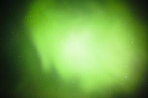 Green glow of aurora borealis in the night sky photo