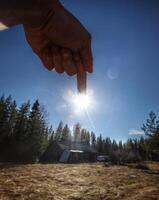 Pointing downwads at the sun and a blurred building photo