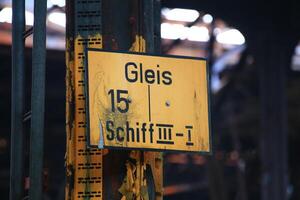 Weathered sign in a railroad workshop with the German words Gleis 15 Schiff III-I track 15 aisle III-I photo