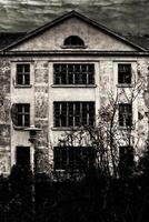 Black and white shot of haunted villa and cloudy sky photo