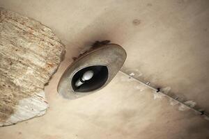 Old Soviet style industrial aluminium lamp at a desolate ceiling photo