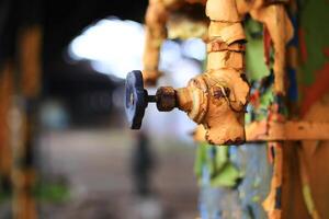 Rusty valve with old yellow paint in an abandoned factory photo